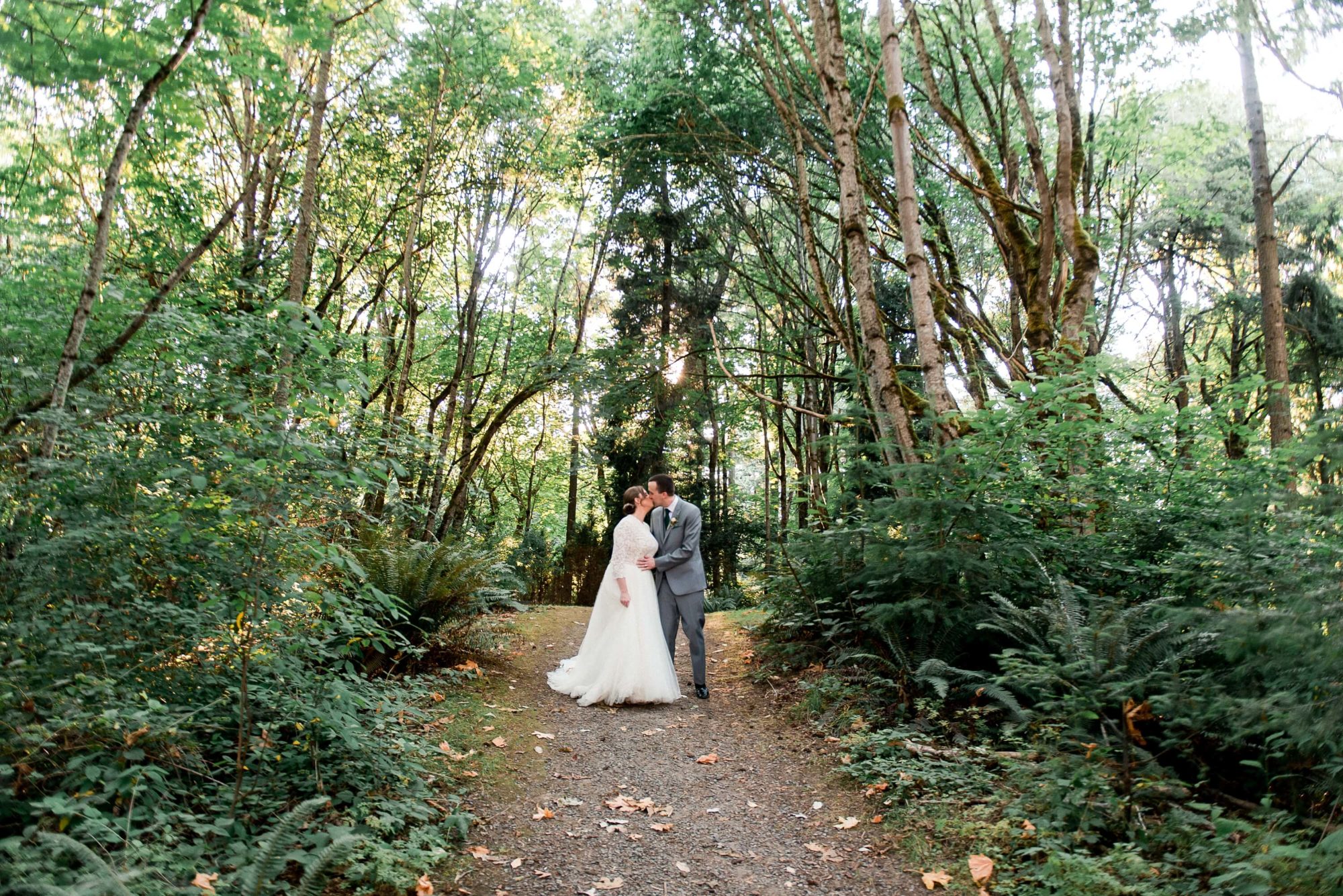 bride and groom kiss in a forest path at The Lodge at St. Edwards Park