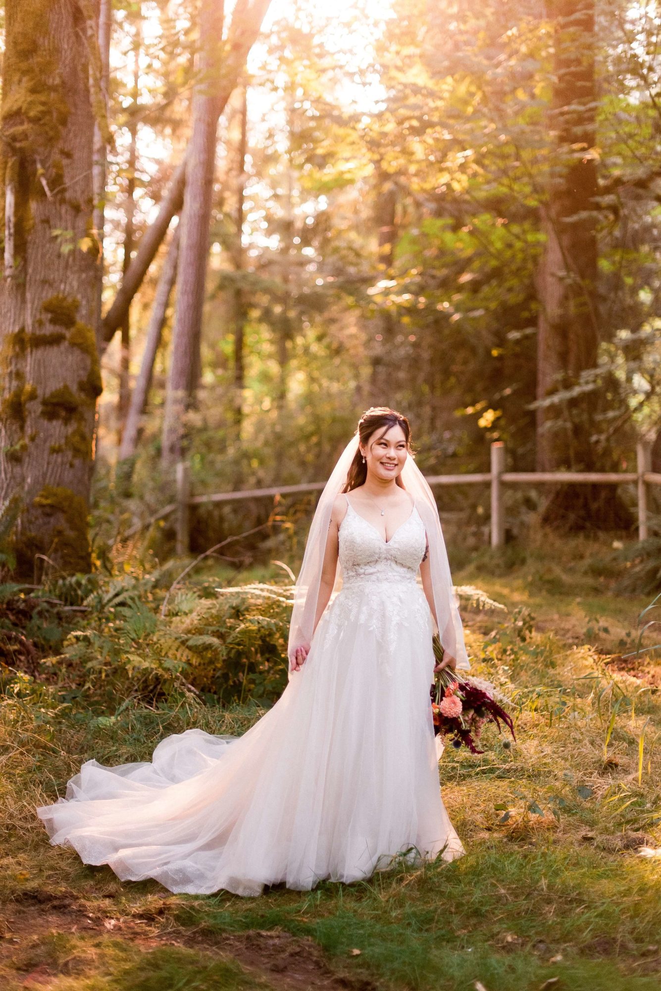 bride with full train stands in the forest with her bouquet at The Lodge at St. Edwards Park
