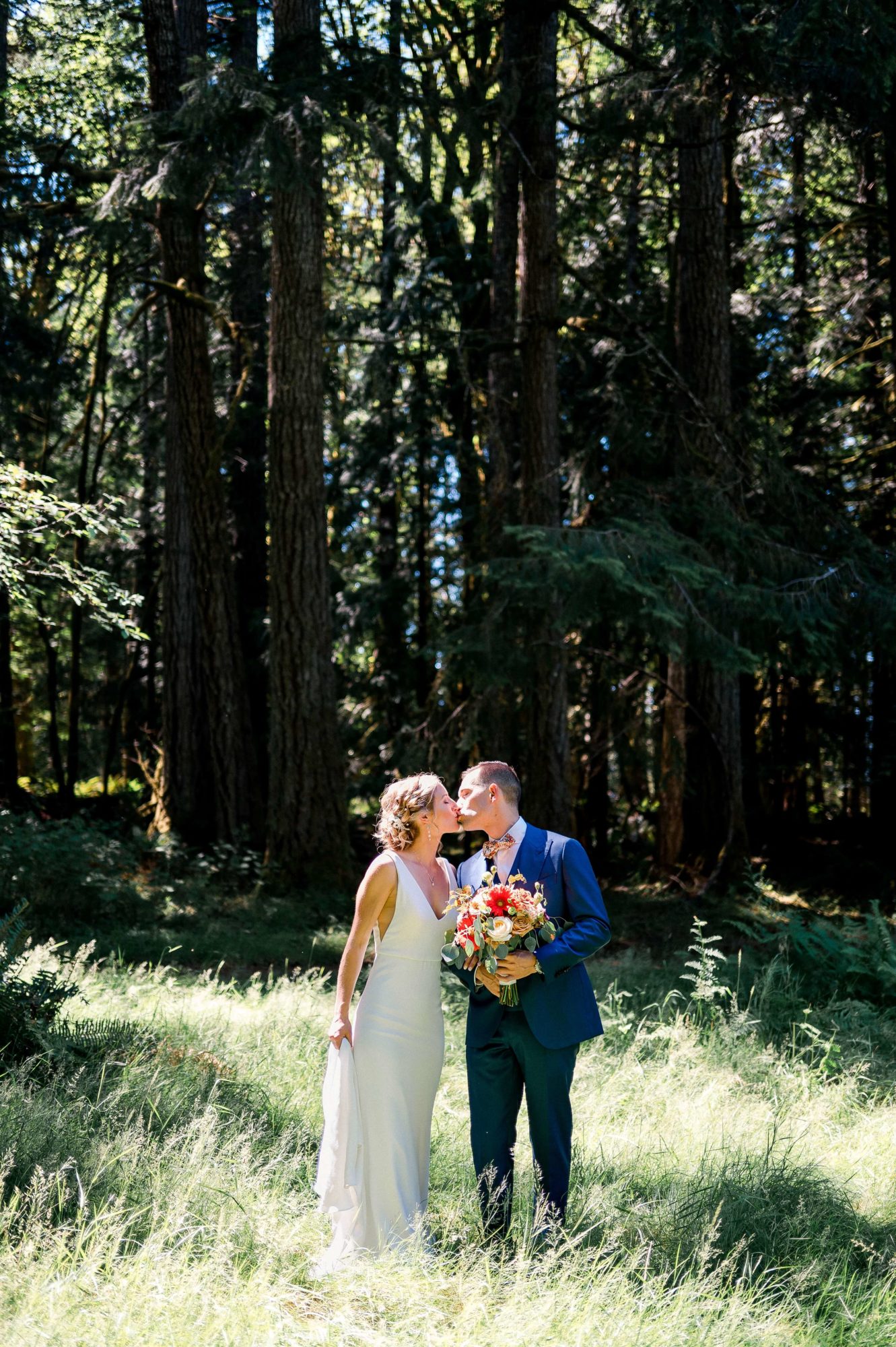 bride and grroom kiss in a grassy green field at The Lodge at St. Edwards