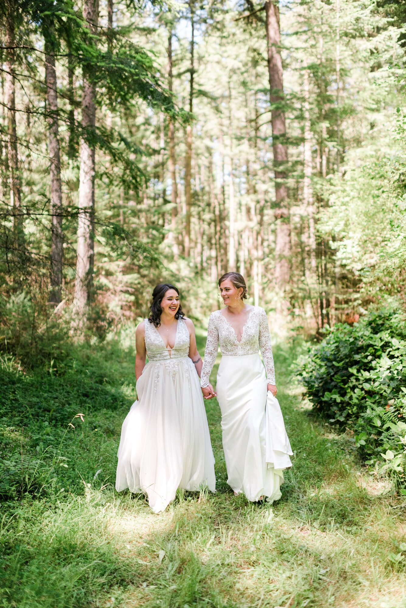 Two brides walking in the forest at their LGTBQ+ wedding at Saltwater farm on San Juan Island