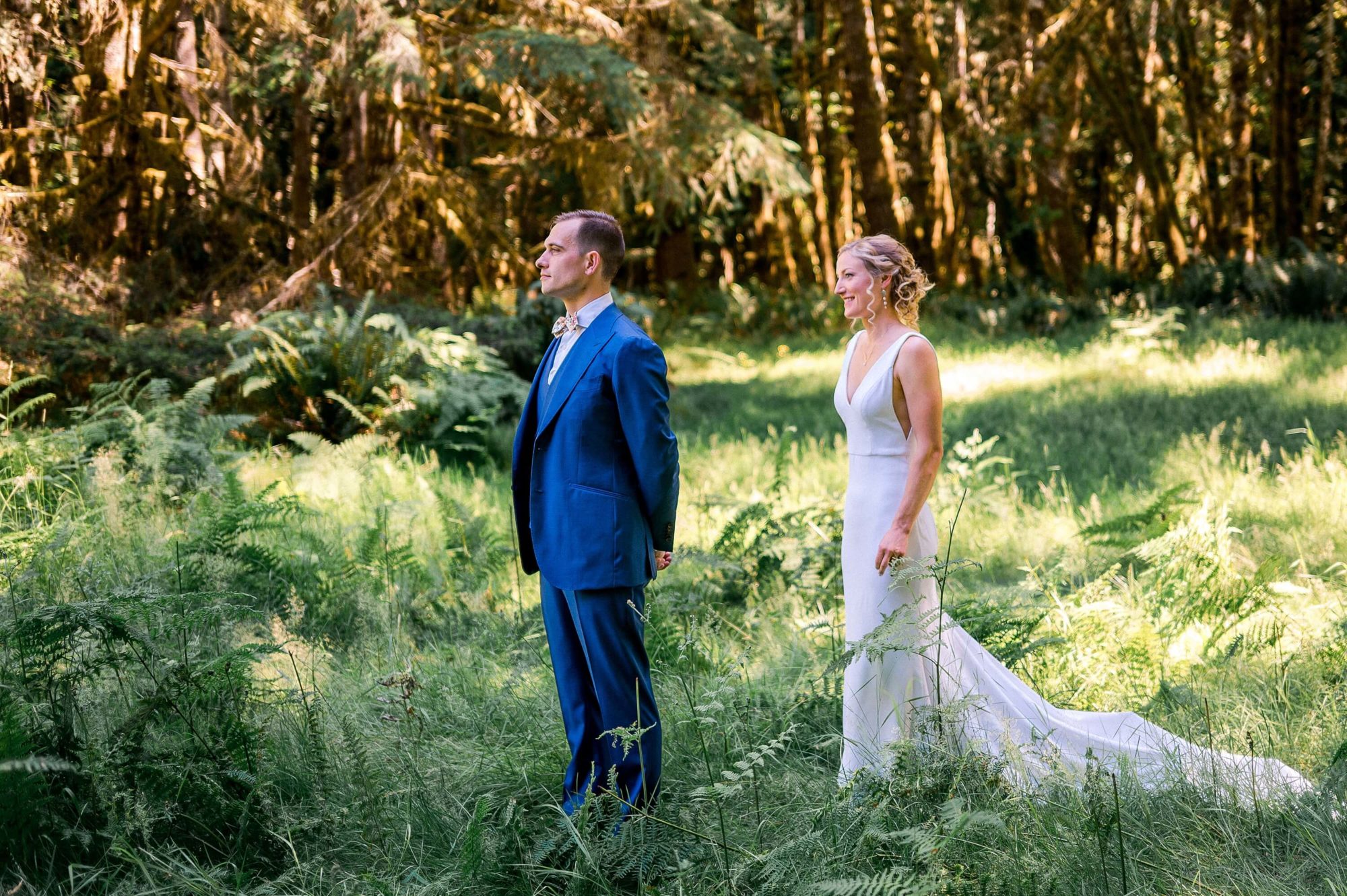 bride approaching her groom in a forest for their first look at Islandwood wedding venue