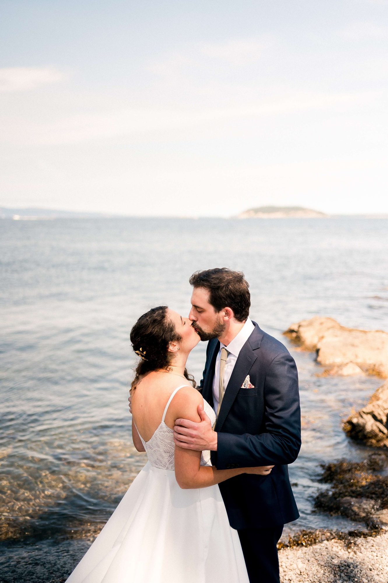 bride and groom sharing a kiss near the water at their at their San Juan Island Wedding
