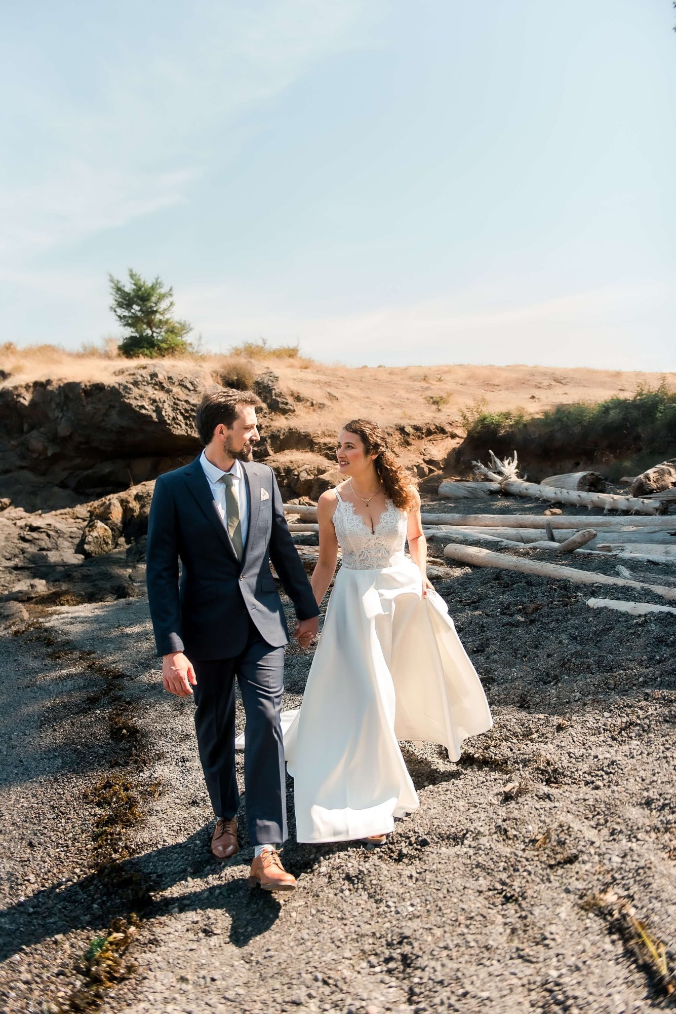 bride and groom walking along the edge of the water at their San Juan Island Wedding