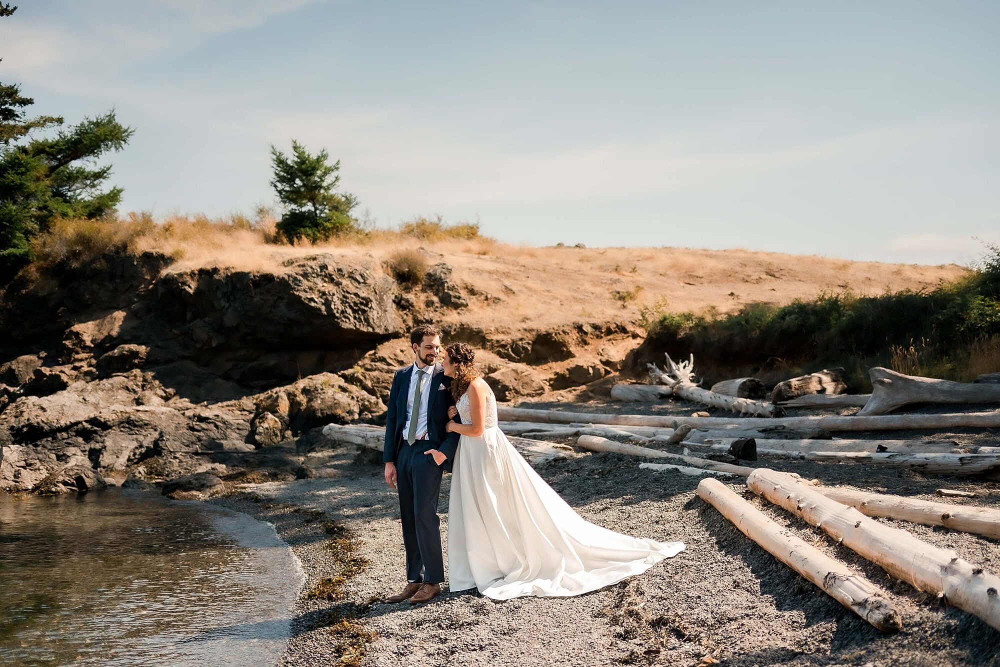 bride and groom laughing near the edge of the water at their San Juan Island Wedding