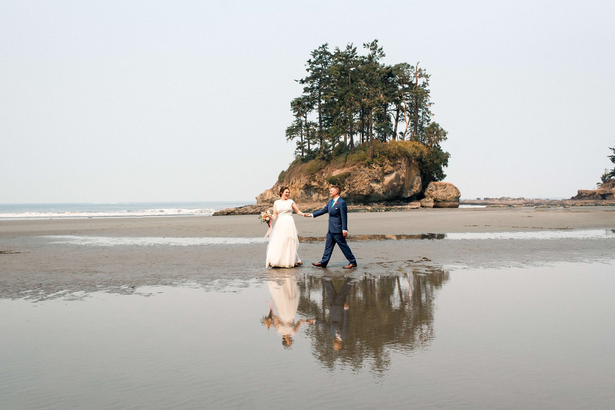 bride and groom walking along the beach at at their Seabrook wedding