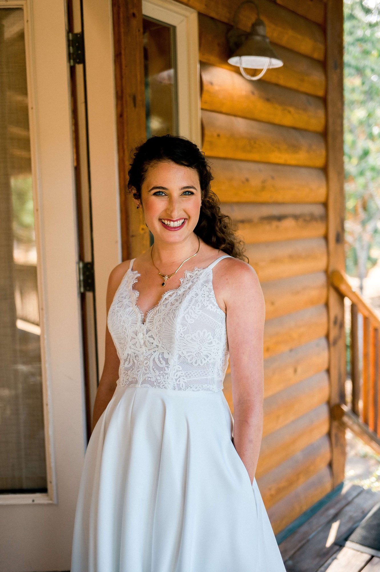 bride smiling in front of a cabin at their Lakedale Resort Wedding