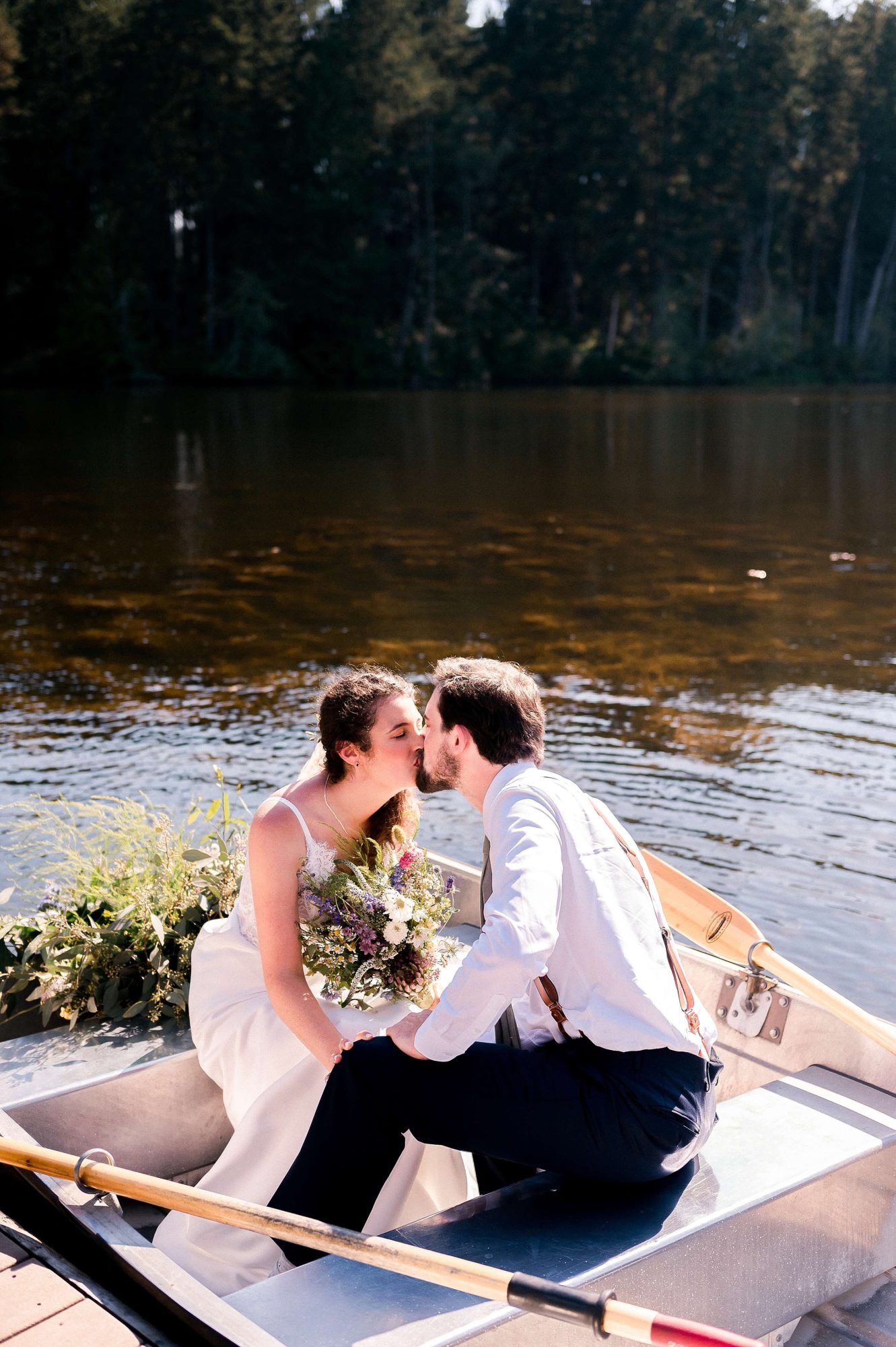 bride and groom kissing in a rowboat at their Lakedale Resort Wedding