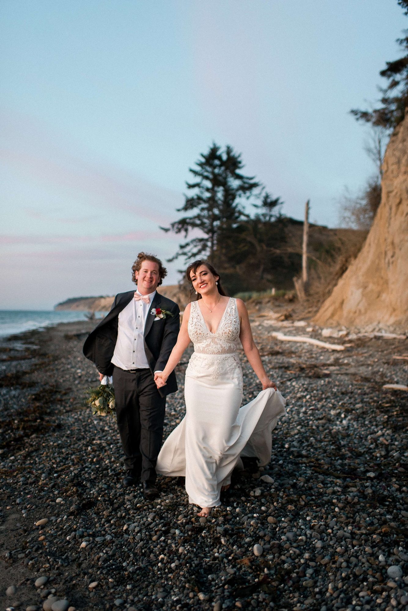 bride and groom smiling as they walk along the beach at their Whidbey Island Wedding