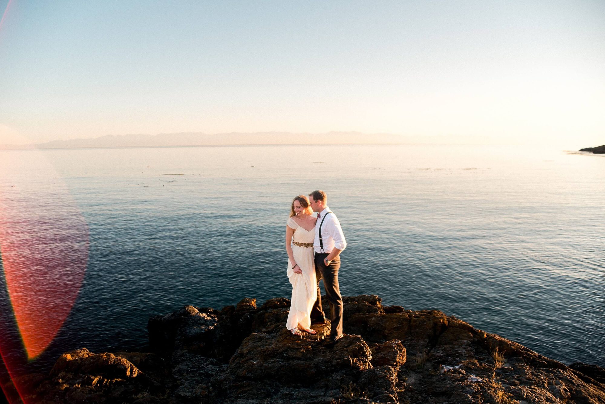 couple standing on rocks by the water at their Whidbey Island Wedding