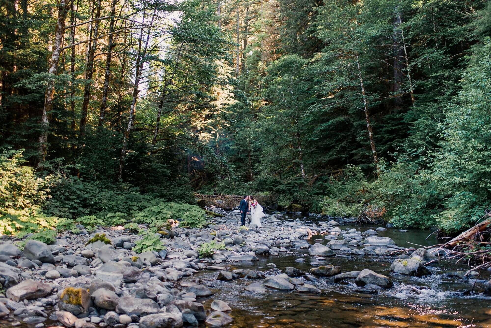Bride and groom by a river in the Hoh Rainforest