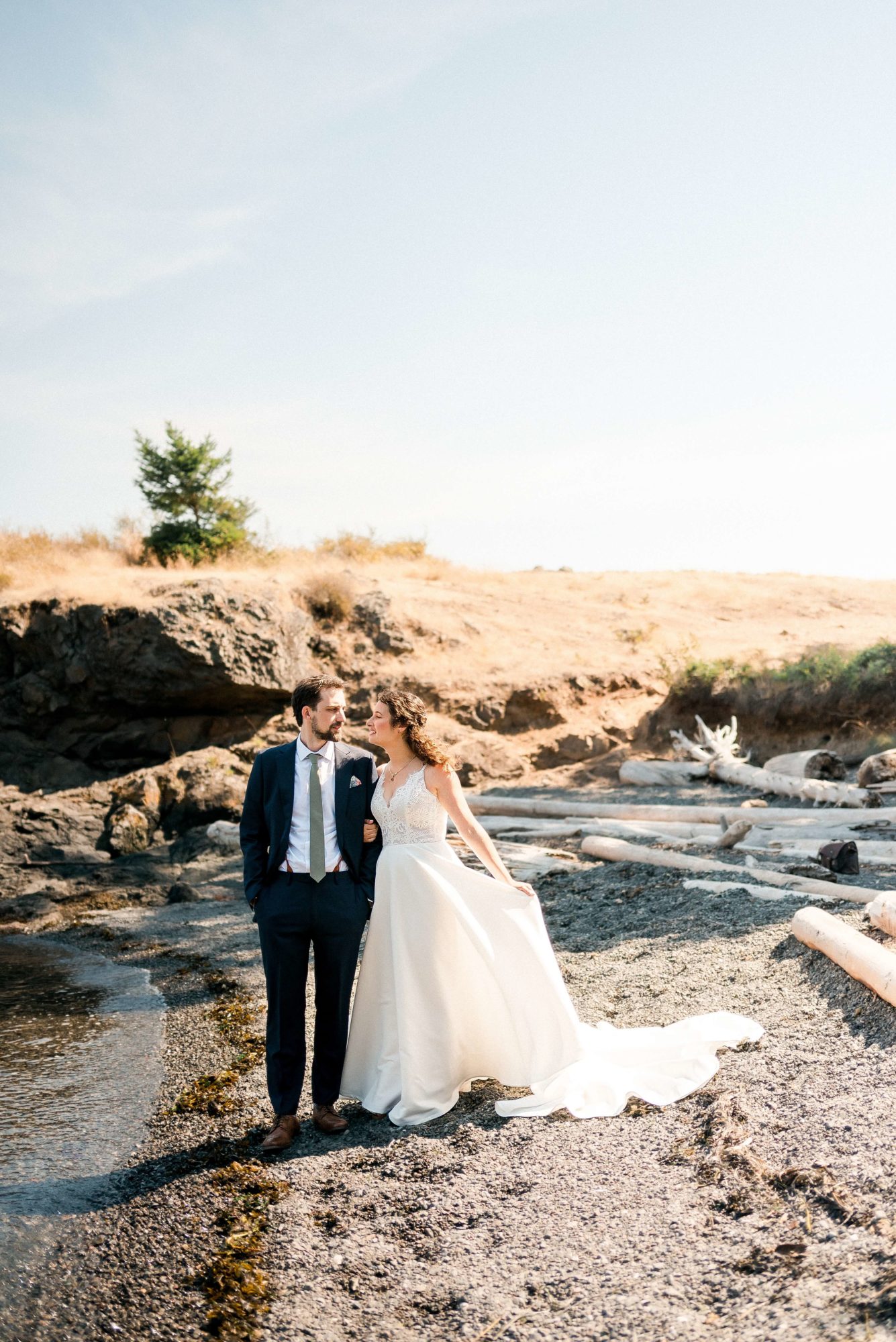 Bride and groom kissing on a rocky beach in the San Juan Islands