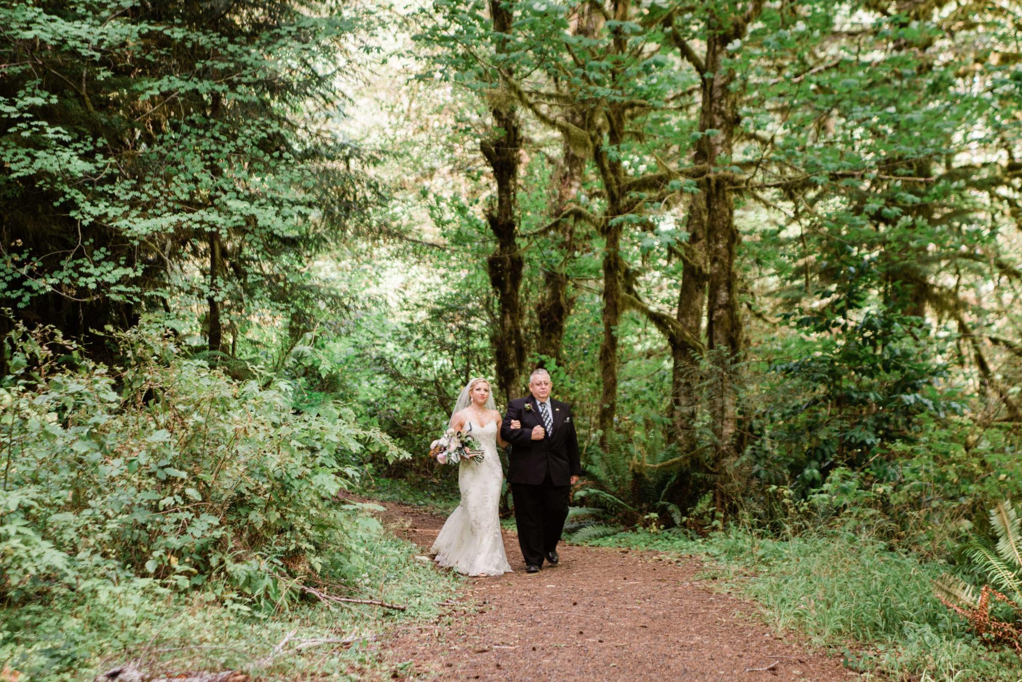 Bride walking down a forest trail in the Hoh Rainforest