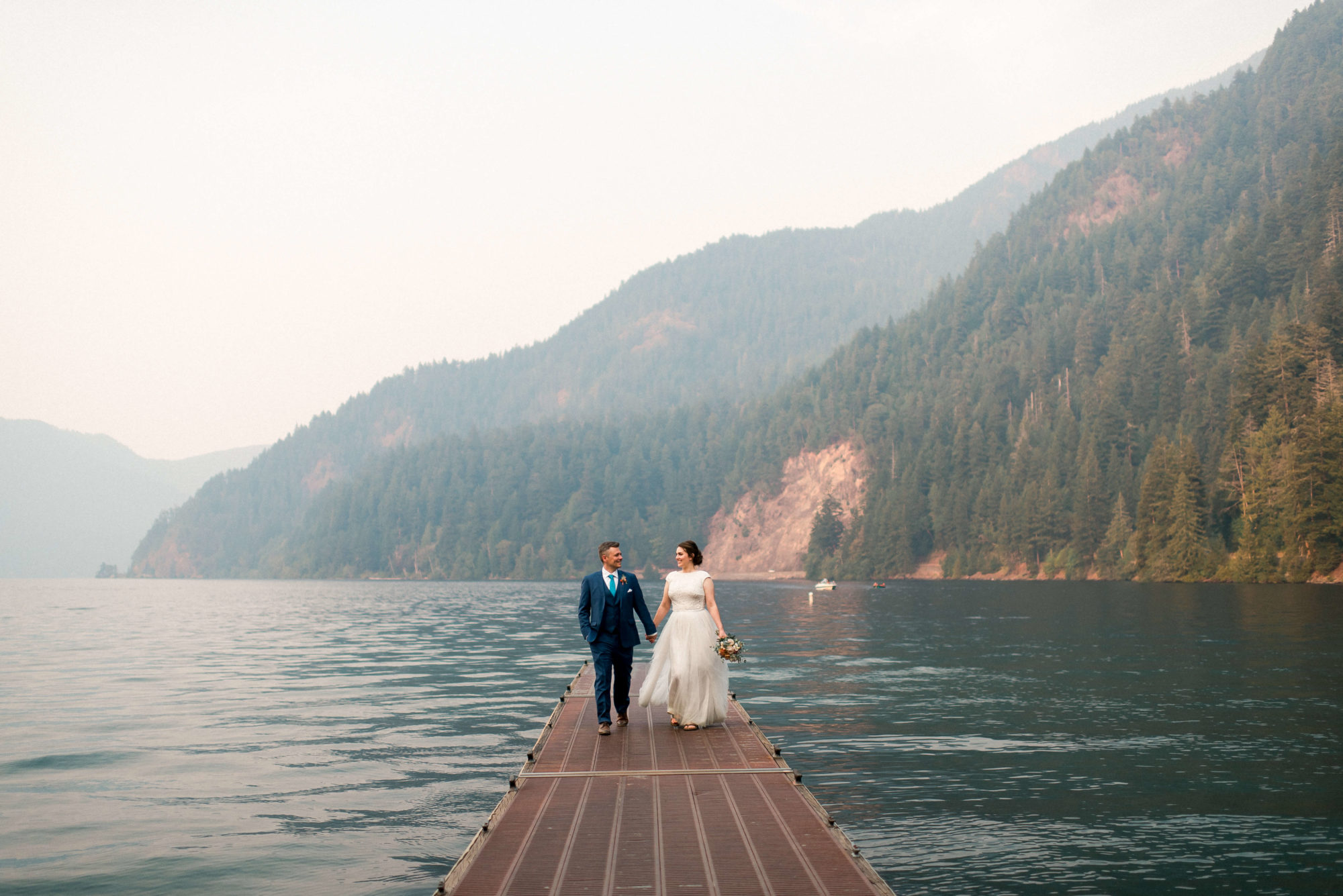 Bride and groom walking on a dock at Lake Crescent