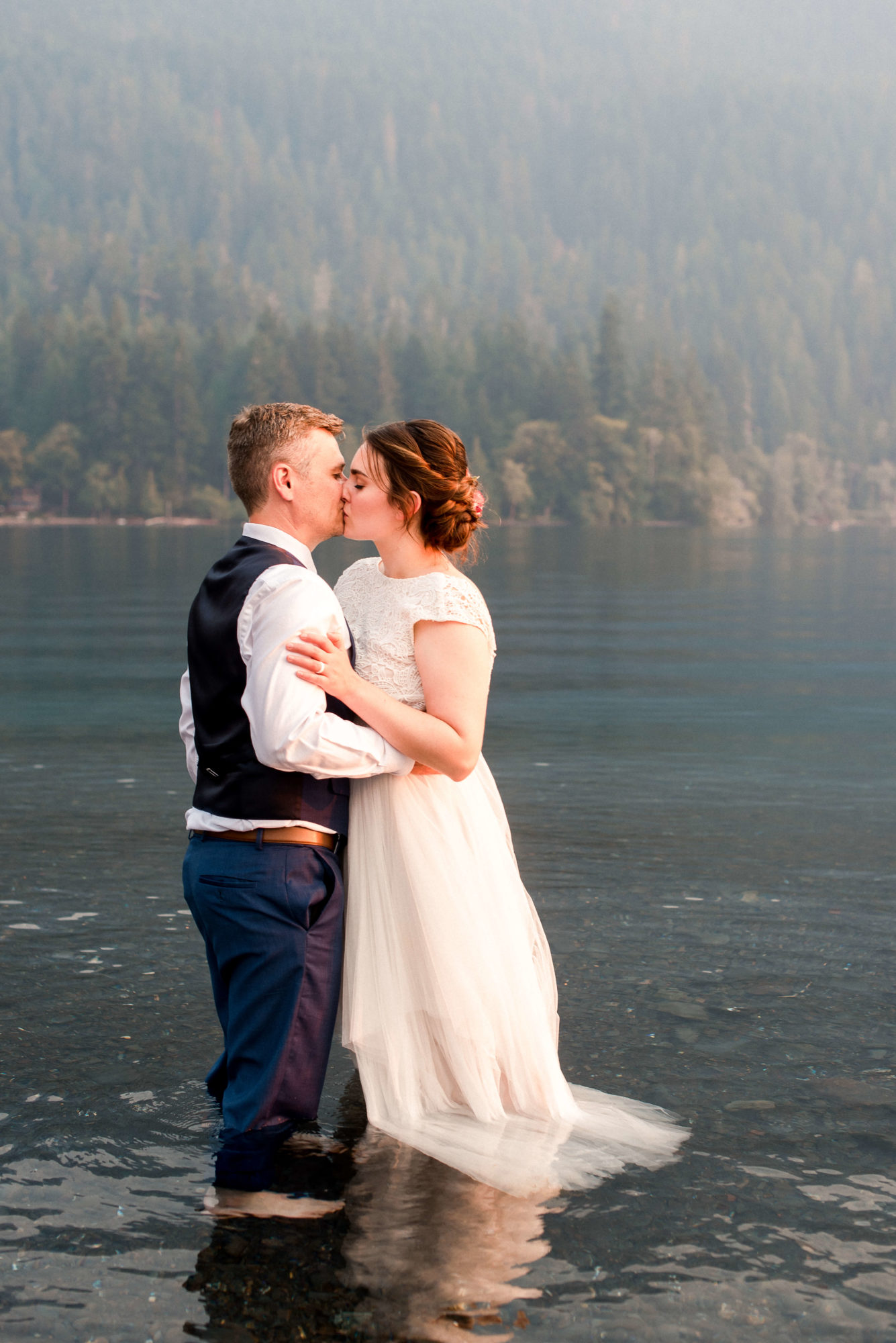 Bride and Groom kissing in the water at Lake Crescent elopement