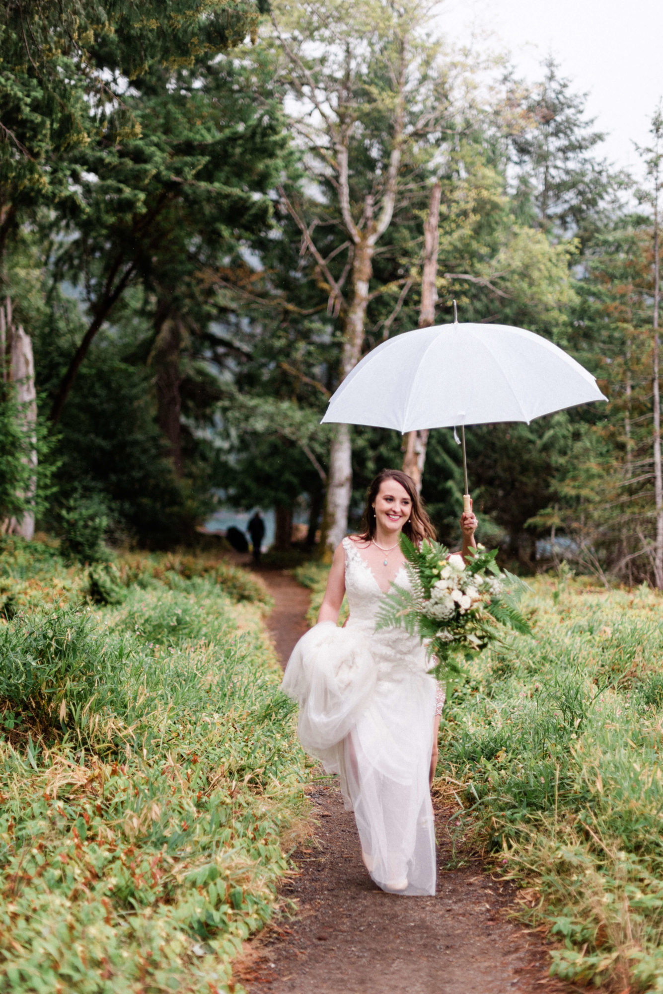 Bride walking in the forest in the rain at Lake Crescent