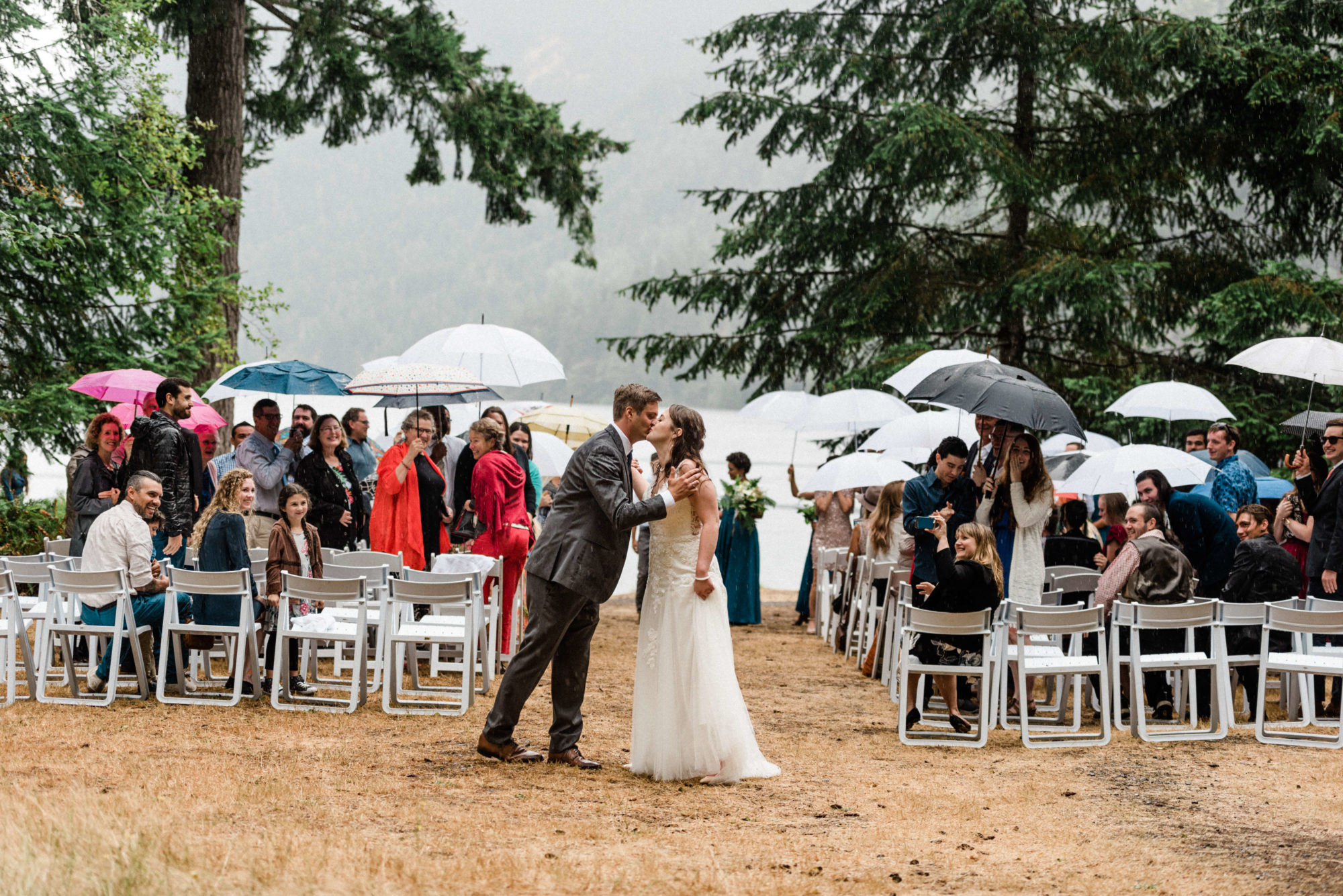 Bride and groom kissing in the rain at Lake Crescent Lodge in Olympic National Park