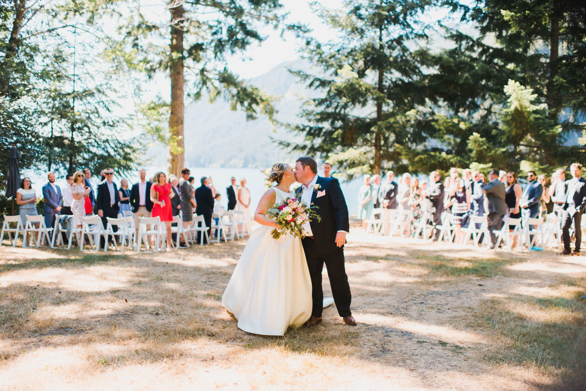 Bride and groom kissing at their wedding ceremony at Lake Crescent Lodge