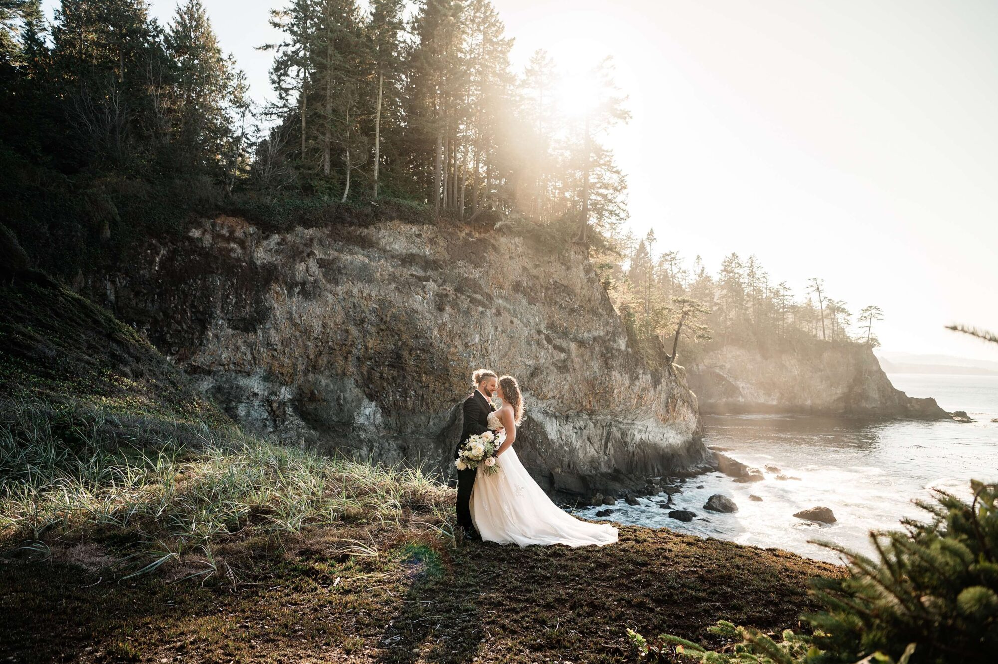 Bride and groom eloping at sunset on a cliff on the Washington Coast
