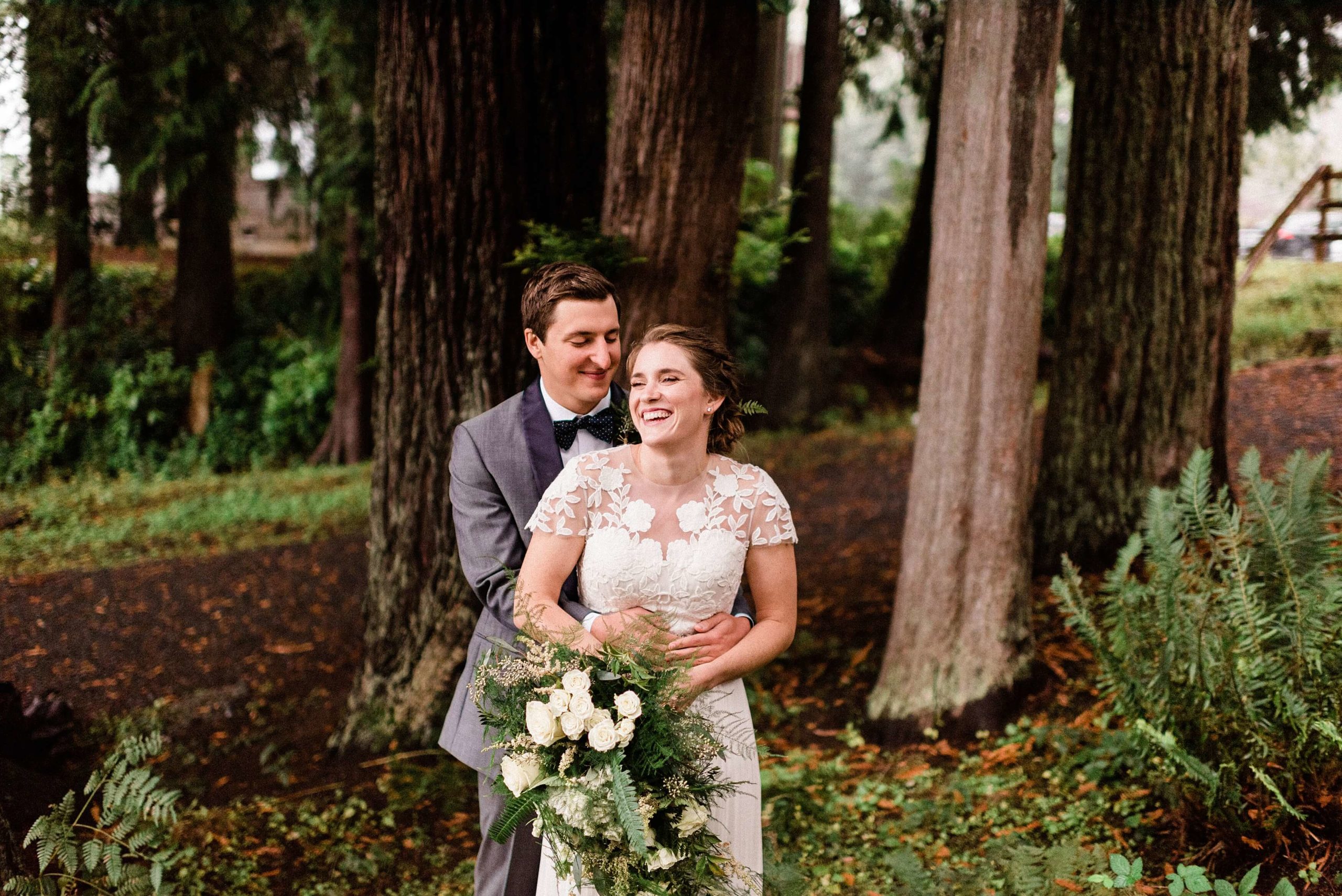 Bride and groom laughing in the forest at Lake Quinault Lodge