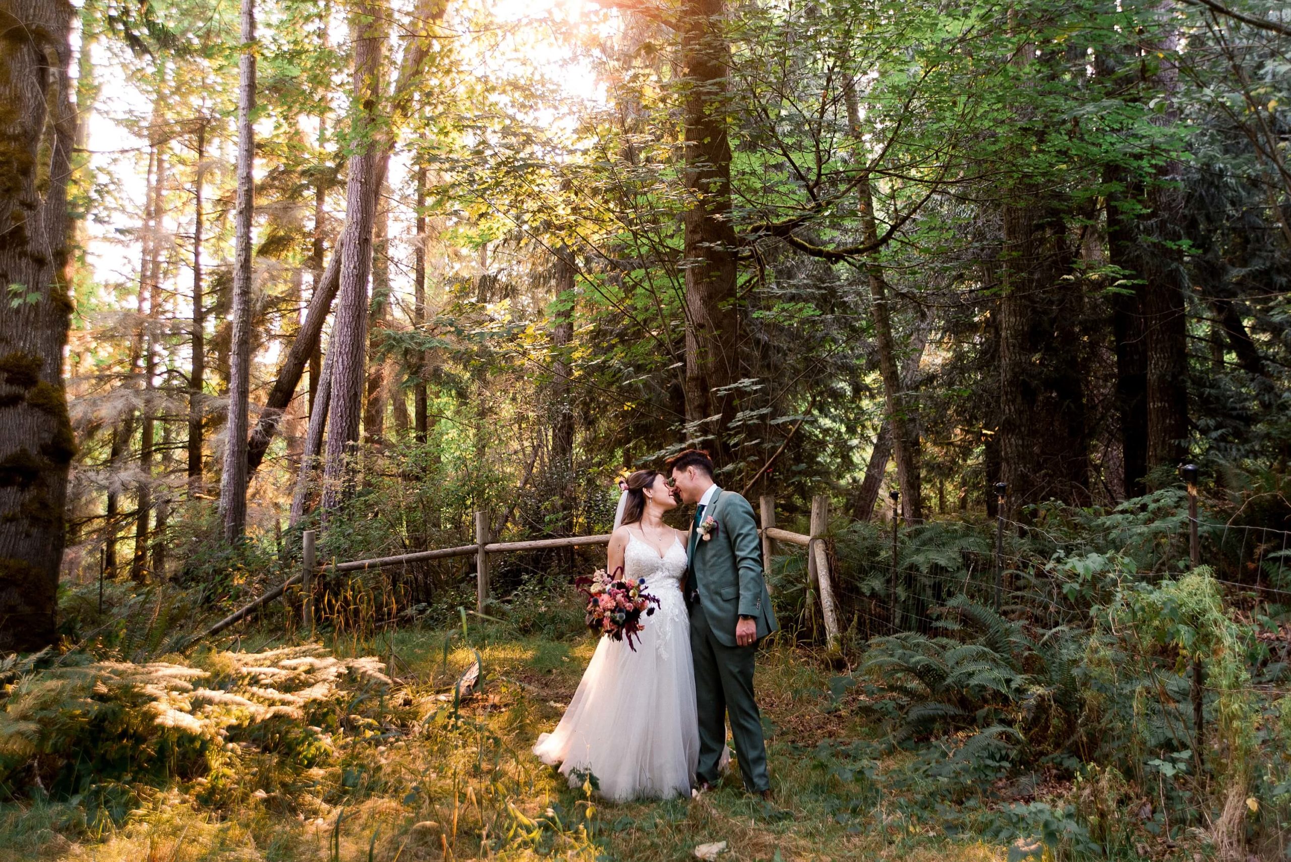 couple touch noses in the forest at a Washington forest wedding venue