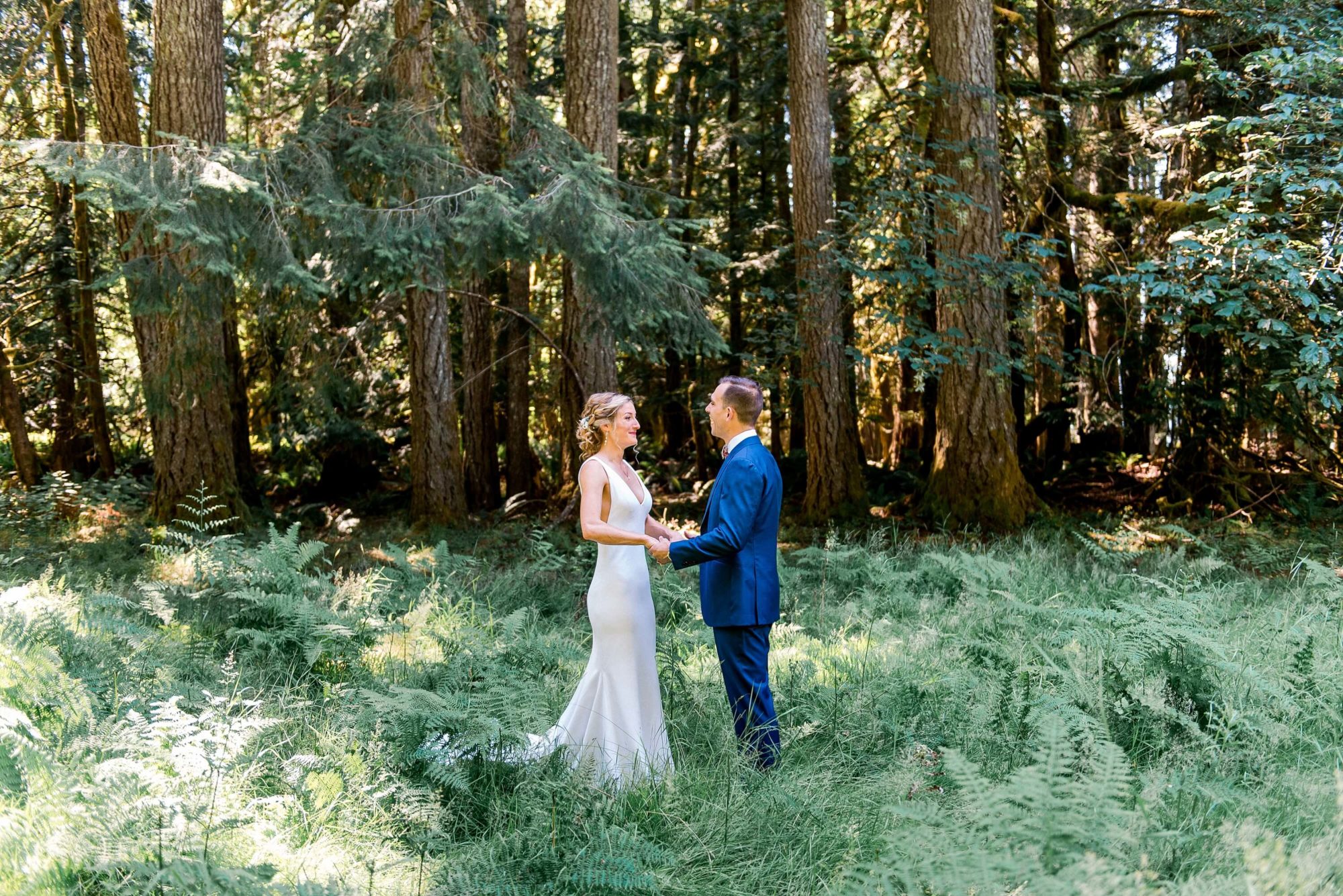 bride and groom enjoying a first look hidden in the forest