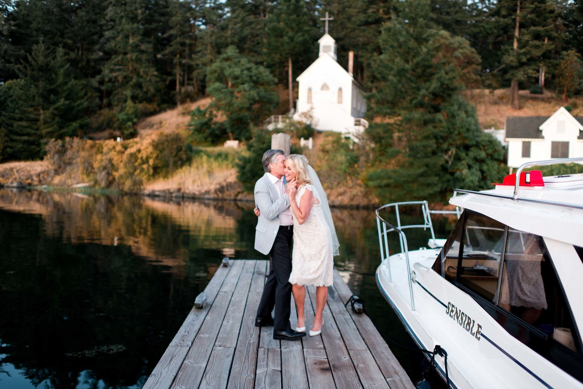 bride and groom sharing a kiss on the deck with their chapel behind them Roche Harbor Wedding