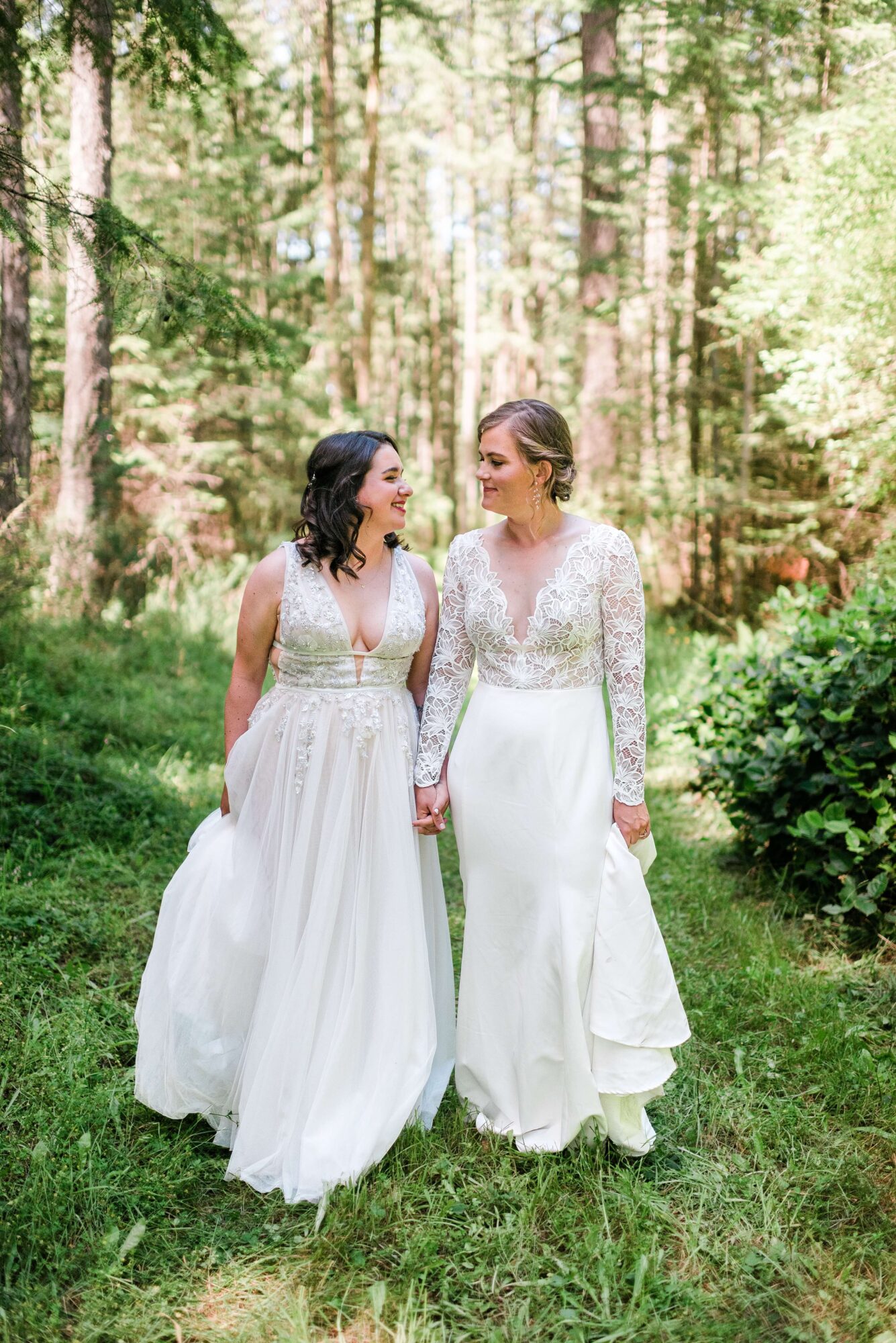 Two brides walking in the forest at their LGTBQ+ wedding at Saltwater farm on San Juan Island
