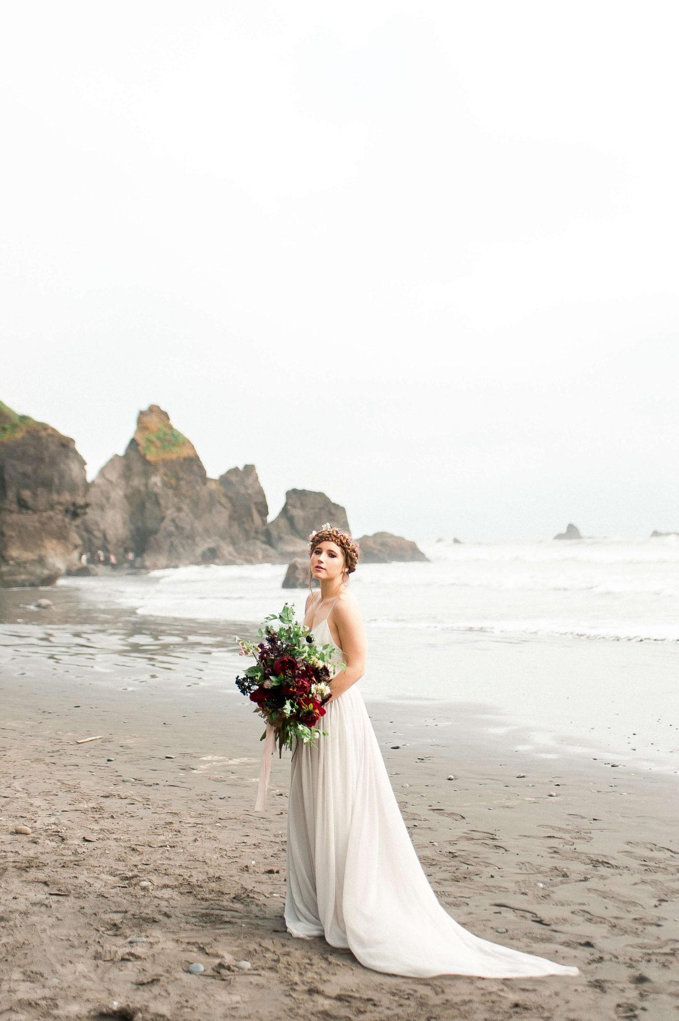 bride with a large bouquet standing on the beach at their Seabrook wedding