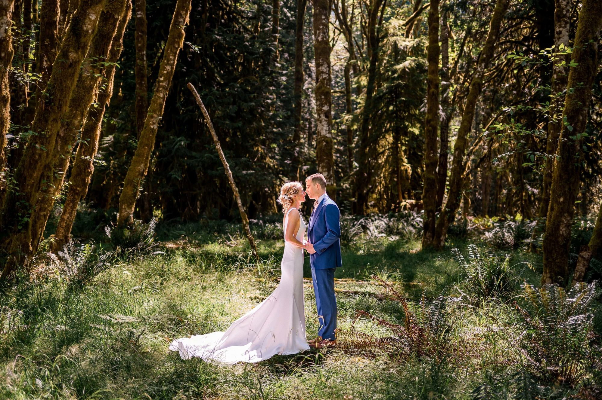 bride and groom kissing in the woods at Fern Acres Forks Wedding Venue