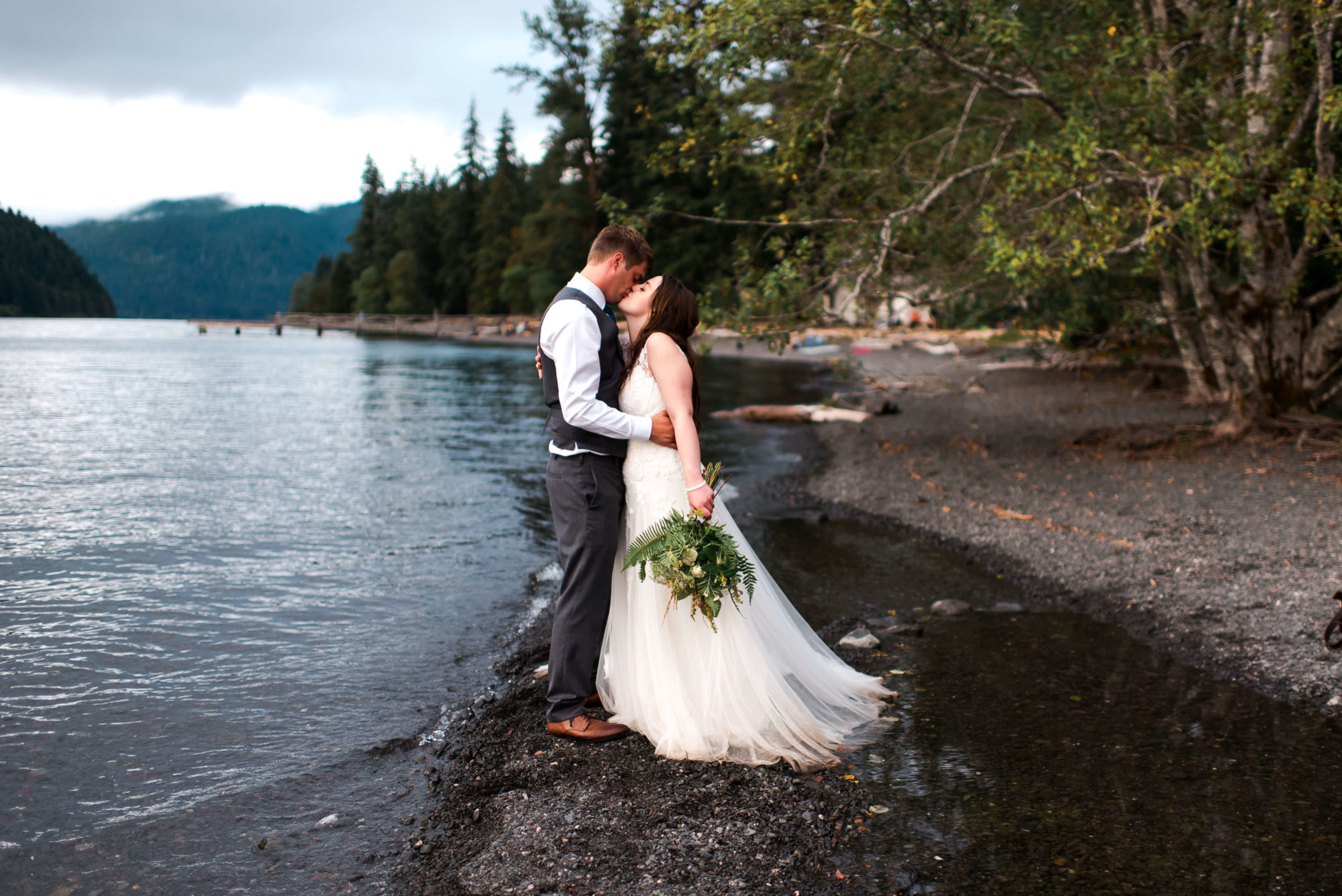 Bride and Groom kissing on the beach at Lake Crescent